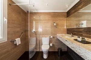 a bathroom with a toilet and a glass shower at Essence Hotel Boutique in Torremolinos
