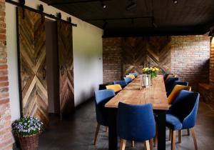 a dining room with a long table and blue chairs at Garden Loft in Roczyny