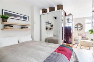1 dormitorio con 1 cama y TV en la pared en Large Luxury Studio in Heart of Richmond, en Richmond