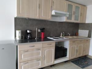 uma cozinha com armários de madeira e um forno de fogão branco em Maison des Flandres em Oxelaere