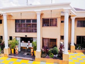 ein Gebäude mit Säulen und Pflanzen davor in der Unterkunft Sonia Hotel in Accra