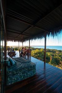 uma cama num deque com vista para o oceano em O Céu de Boipeba na Ilha de Boipeba