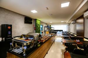 a restaurant with a buffet line with tables and chairs at Transamerica Fit Vitória Praia de Camburi in Vitória