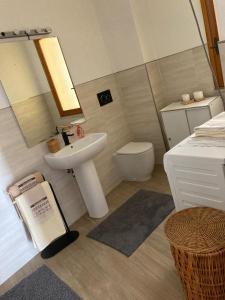 een badkamer met een wastafel, een toilet en een spiegel bij M'illumino d'immenso - MONEGLIA APARTMENTS in Moneglia +33 foto's