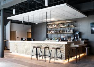 a bar with two stools and a counter with drinks at SOVA Micro-Room & Social Hotel in Dallas