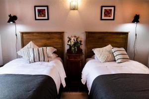 two beds in a hotel room with flowers on them at Casa Aurora, estilo rústico-moderno, Guanajuato in Guanajuato