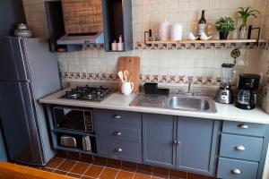 a small kitchen with a sink and a stove at Casa Aurora, estilo rústico-moderno, Guanajuato in Guanajuato