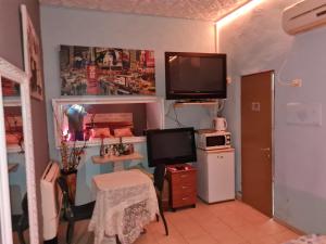 um pequeno quarto com uma televisão e um tvicterictericterswersswersswers em vacation house יחידת אירוח פרטית הוד השרון em Hod HaSharon