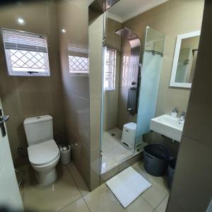 uma casa de banho com um chuveiro, um WC e um lavatório. em Overport Durban Halaal Accommodation "No Alcohol Strictly Halaal No Parties" Entire Luxury Apartment, 2 Bedroom, 4 Sleeper, Self Catering, 300m from Musjid Al Hilaal em Durban