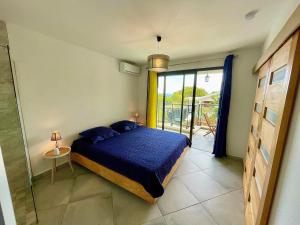 a bedroom with a blue bed and a large window at Résidence Amarosa in Les Avirons +58 photos
