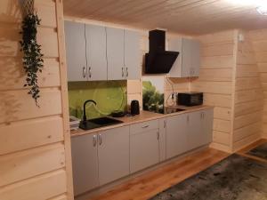 a kitchen with white cabinets and a sink at Wypoczynek u Hazów in Chochołów