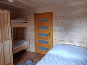 a bedroom with two bunk beds and a door at Wypoczynek u Hazów in Chochołów