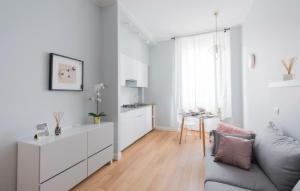 Il comprend un salon blanc avec un canapé et une cuisine. dans l'établissement Farini Suite, à Milan
