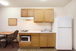 cocina con mesa y nevera blanca en WoodSpring Suites Odessa, en Odessa