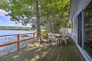 a porch with a table and chairs and a view of a lake at Quiet and Lovely Lakefront Cottage for Families! in Union