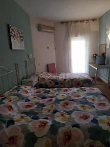 1 Schlafzimmer mit einem Bett mit Blumenbettdecke in der Unterkunft Hostal Ruta Del Sur in Huéscar