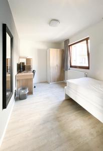 ein weißes Schlafzimmer mit einem Bett und einem Fenster in der Unterkunft Traumhaftes Privatzimmer in Karlsruhe in Karlsruhe