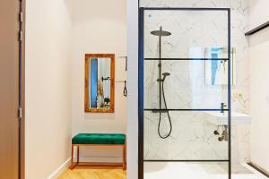 baño con ducha con taburete verde en Hotel Les Ecrins, en Bruselas