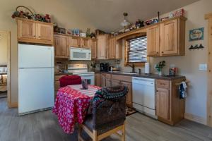 a kitchen with a table and a white refrigerator at Calhoun House Inn & Suites in Bryson City