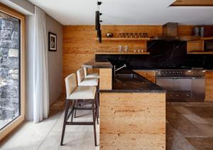 eine Küche mit einer Bar mit Hockern in der Unterkunft Regent Retreat by MC in Rougemont