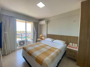1 dormitorio con 1 cama grande y balcón en AllMar Flats - Apartamentos frente mar - Beach Village, en Fortaleza