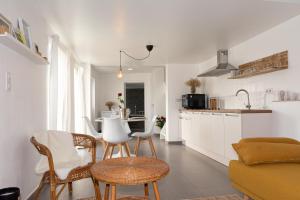 een keuken en een woonkamer met een tafel en stoelen bij L'Entre-Temps in Xhendelesse