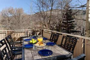 a wooden table with plates of food on a balcony at Deluxe Two Bedroom - Aspen Alps #504 in Aspen