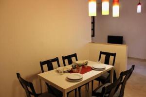 uma mesa de jantar com 4 cadeiras, uma mesa e uma espreguiçadeira em WISH SUITE MORERA em Sevilha