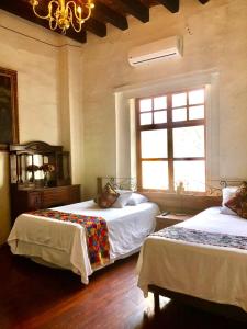 a bedroom with two beds and a window at Hotel Boutique Los Camilos in Mexico City