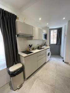 a kitchen with a sink and a washing machine at Studio Hirondelle in Portiragnes