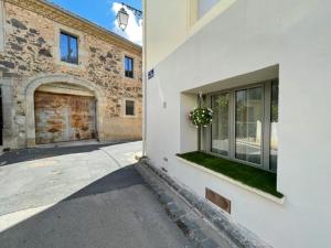 a white building with a door and a plant in a window at Studio Hirondelle in Portiragnes