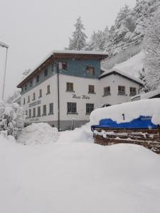 a snow covered building in front of a mountain at Haus Hotz in Landeck