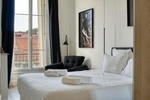 - une chambre avec un lit, une chaise et une fenêtre dans l'établissement Superbe 3 pièces refait à neuf classé 4 étoiles avec ascenseur et balcon à pied de la plage et du palais des festivals, à Cannes