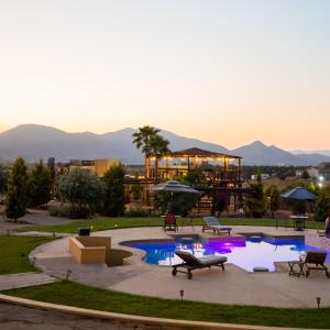 um resort com piscina e montanhas ao fundo em Cuatro Lunas Hotel Boutique em Valle de Guadalupe