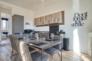 a kitchen and dining room with a table and chairs at Superbe 3 pièces refait à neuf classé 4 étoiles avec ascenseur et balcon à pied de la plage et du palais des festivals in Cannes