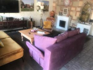 sala de estar con sofá púrpura y mesa en Ferienwohnung WohlFühlWohn, en Vreden