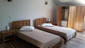 two beds in a room with two tables and a bedroom at Zodiac in Caransebeş