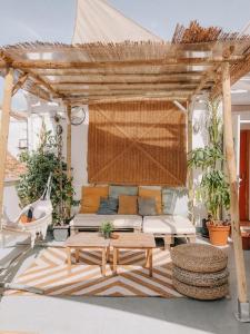 een houten pergola met een bank en een tafel bij The Urban Jungle Hostel in Málaga