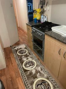 a kitchen with a stove and a rug on the floor at 8 Berth on The Grange (Summer) in Ingoldmells