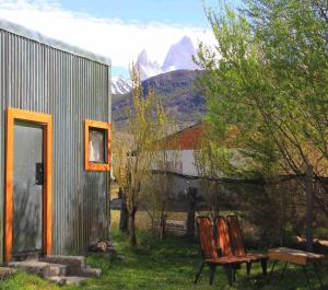 two chairs and a bench in front of a house at Don Galle in El Chalten