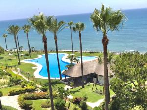 Luftblick auf ein Resort mit Palmen in der Unterkunft MI CAPRICHO BEACHFRONT- 3-7 Apartment with sea views in Mijas Costa