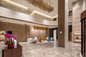a lobby of a hotel with purple flowers and chairs at Ramada Encore by Wyndham Dongguan East in Dongguan