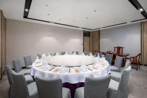 een vergaderruimte met een grote tafel en stoelen bij Ramada Encore by Wyndham Dongguan East in Dongguan