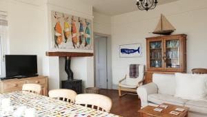 een woonkamer met een bank en een tafel bij THE CREST- 4 BED SEA VIEW PROPERTY -TREARDDUR BAY in Trearddur