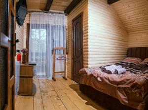 a bedroom with a bed in a log cabin at Карпатське Щастя in Verkhovyna +133 photos