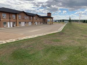 an empty parking lot in front of a building at SureStay Studio by Best Western Hardisty in Hardisty