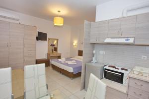 a room with a kitchen and a bed in it at Aspous Studios and Rooms in Skiros +29 photos