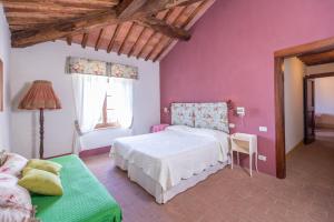 um quarto com uma cama branca e paredes cor-de-rosa em Agriturismo Tenuta Armaiolo em Rapolano Terme