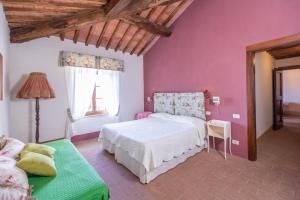 ラポラーノ・テルメにあるAgriturismo Tenuta Armaioloのピンクの壁のベッドルーム1室(白いベッド1台付)