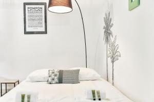 - une chambre avec un lit doté de draps blancs et d'une lampe dans l'établissement Spacious and modern flat - Toulouse - Welkeys, à Toulouse